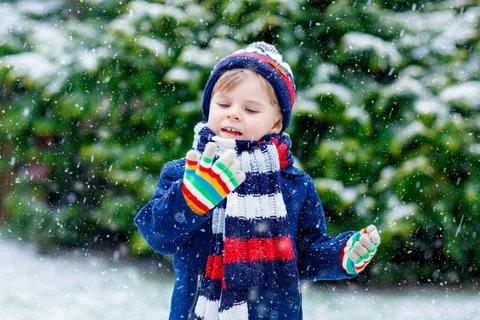 Cute little funny child in colorful winter fashion clothes having fun and Stock Photos