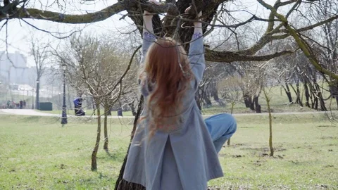 Cute little gil climbing up a tree and hanging upside down Stock Footage 74229470