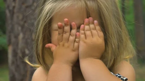 Cute little girl close her face with hands Stock Footage