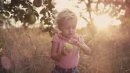A Cute Little Girl In A Field Holding An Apple That She Just Picked Stock Footage