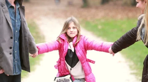 Cute little girl holding hands with parents, preparing to jump Stock Footage 59554449