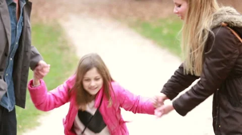 Cute little girl holding hands with parents and jumping Stock Footage 59554459