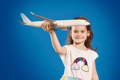 Cute little girl is holding a white plane and smiling Stock Photos