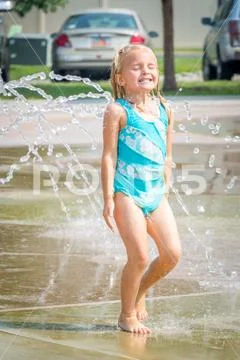 Cute Little Girl Playing in Water at Splash Pad Stock Photos