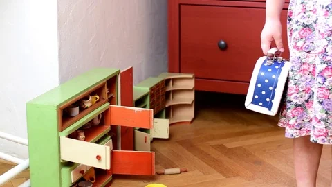 Cute little girl plays with vintage toys. Girl's body, girl wears flowered dress Stock Footage