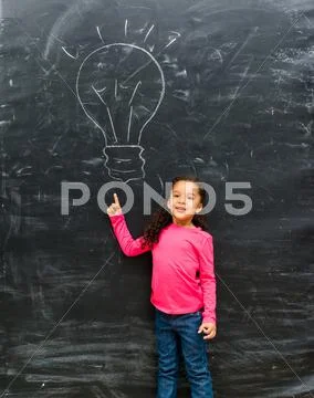 Cute little girl pointing on a drawn lamp Stock Photos