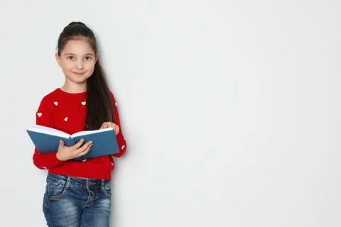 Cute little girl reading book on white background, space for text Stock Photos