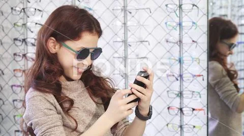 Cute little happy girl taking selfies at the eyewear store Stock Photos