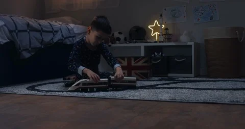 Cute little kid boy assembles radio controlled train in his room Stock Footage 105814012