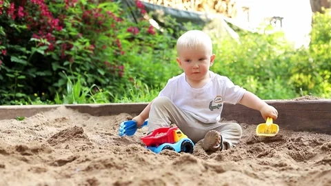 Cute little kid having fun with sand and colorful toys in the park, on a good Stock Footage 155905626