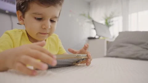 Cute little kid using smartphone at home Stock Footage 247946792