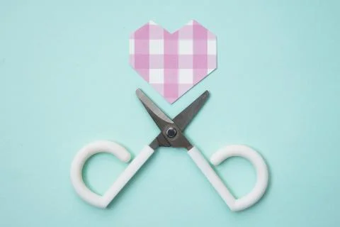 A cute little pair of scissors that try to cut hearts. Foto stock