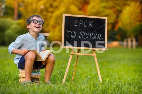 Cute little schoolboy reading book Stock Photos