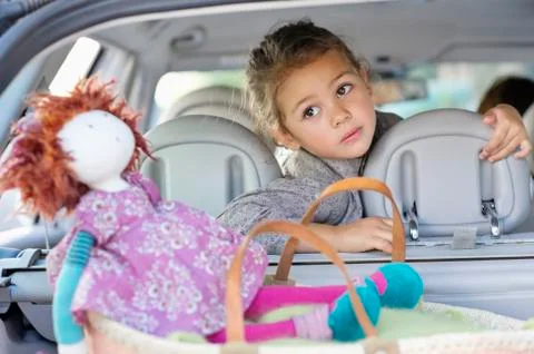 Cute little sitting in a car while mother driving the car Stock Photos