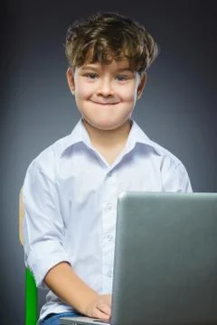 Cute little smiling boy using laptop isolated grey background Stock Photos