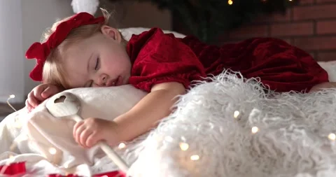 Cute little two year old baby girl in beautiful red dress sleeping under a Chris Stock Footage 259236537