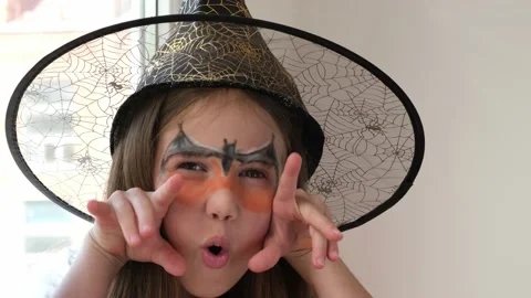 Cute little witch with aqua makeup saying boo on Halloween party Video stock 212124119