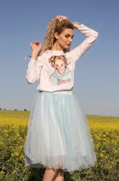 Cute look. Blonde model posing in white and blue romantic dress. Stock Photos