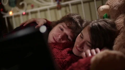 Cute Lovers Snuggling in Bed While Watching Streamed Video Stock Footage 72197455