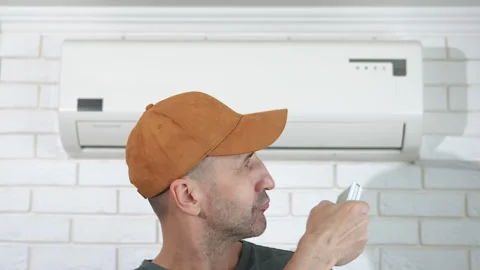 Cute man by air conditioner Stock Footage 301919226