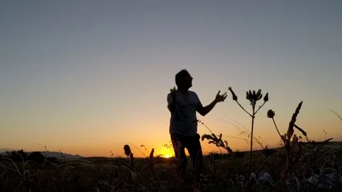 Cute man dancing in the field in the evening Stock Footage