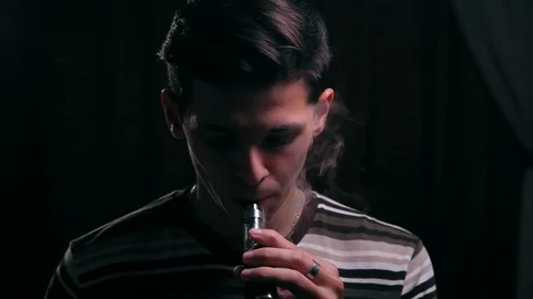 Cute man doing double O's with a electronic cigarette. Vaping tricks at home 動画素材 99050726