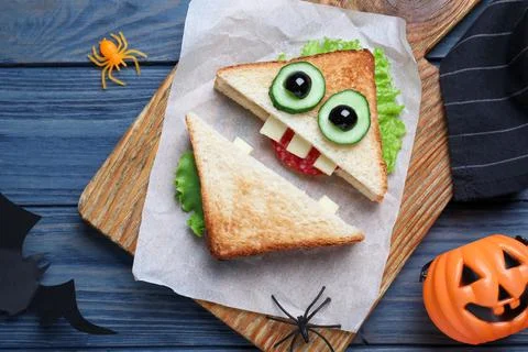 Cute monster sandwich served on blue wooden table, flat lay. Halloween party  Stock Photos