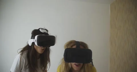 Cute multiracial Girls in virtual Reality helmets at home Two young women in Vídeos de archivo 221451437