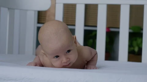 Cute newborn baby lying on the bed on his belly. Motherhood Stock Footage 306014157