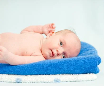 Cute newborn baby lying on a stack of towels Stock Photos