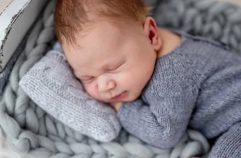 Cute newborn on tiny bed Stock Photos