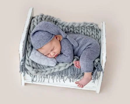 Cute newborn on tiny bed Stock Photos