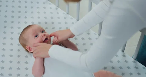 Cute newborn two-three month old baby playing with mother hands by lying in the Stock Footage 219353629