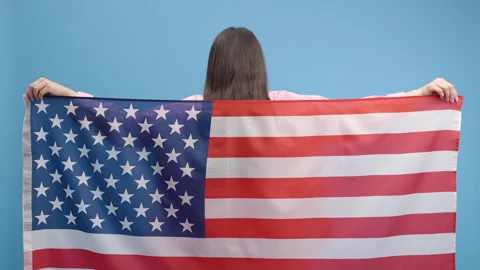 Cute nice attractive young brunette woman wrapping American flag Video stock 243736688