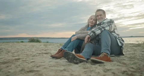 Cute old grey-haired couple of mature loving beautiful wife sitting on beach Stock Footage 223000226