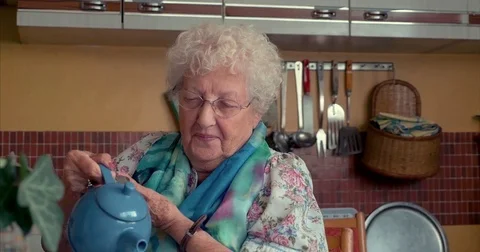 Cute old lady serving and drinking tea Stock Footage 81358160
