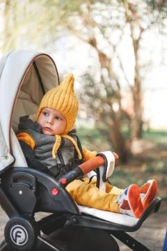 Cute one-year-old boy in a stroller playing Stock Photos