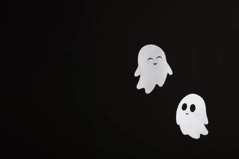 Cute paper ghosts on a black background. Minimalistic banner for Halloween Stock Photos