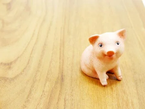 Cute piglet figure with space copy on wooden background Stock Photos