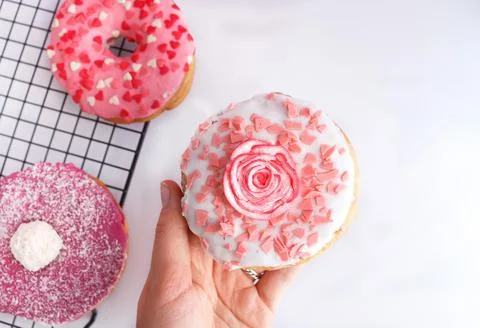 Cute pink donut with rose decor on white background Stock Photos