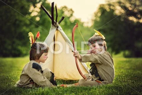 Cute portrait of native american boys with costumes, playing outdoor in the p Stock Photos