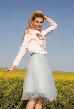 Cute posing and smiling model in romantic dress posing in countryside backgro Stock Photos