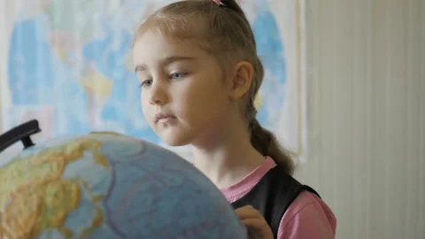 Cute pupil looking at globe in library at the elementary school. Travel plann 库存影片 106715046