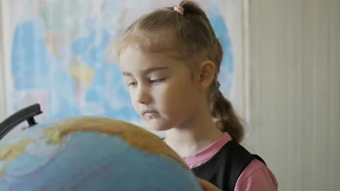 Cute pupil looking at globe in library at the elementary school. Travel plann Видео 119058048