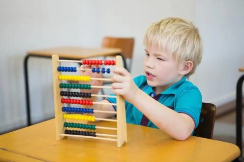 Cute pupil using abacus in classroom 写真素材