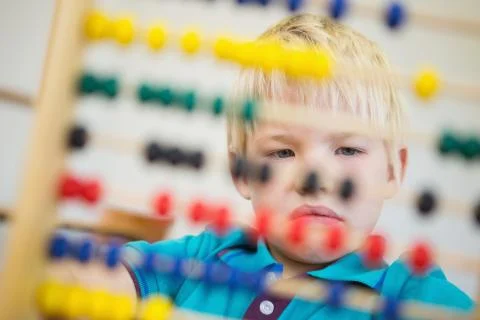 Cute pupil using abacus in classroom Stock Photos