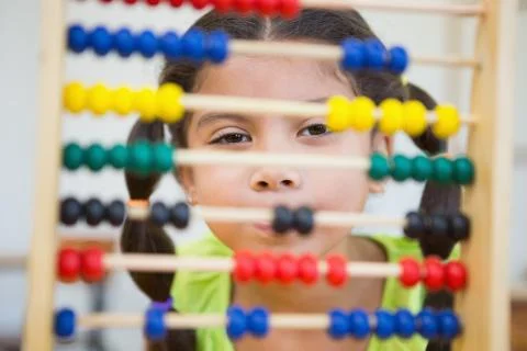 Cute pupil using abacus in classroom 写真素材