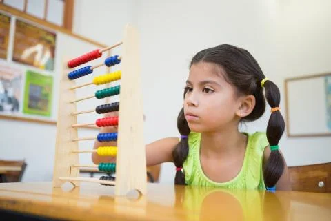 Cute pupil using abacus in classroom 写真素材