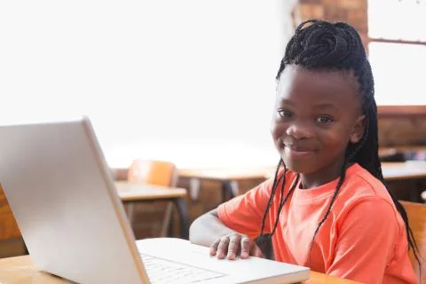 Cute pupil using laptop in classroom 写真素材