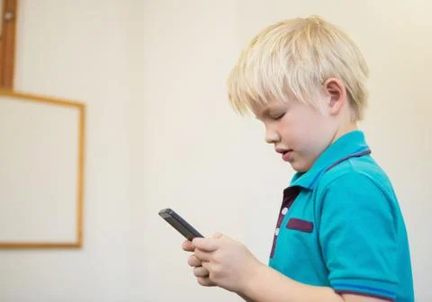 Cute pupil using smartphone in classroom Foto stock